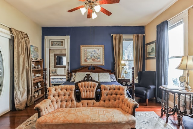 bedroom with ceiling fan, dark wood-type flooring, and multiple windows