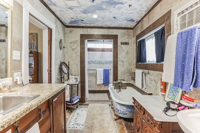 bathroom featuring tile walls, independent shower and bath, vanity with extensive cabinet space, tile floors, and ornamental molding