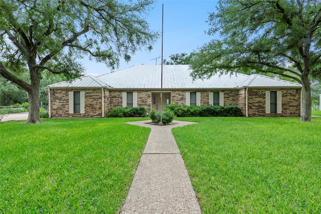 single story home featuring brick siding, metal roof, and a front lawn