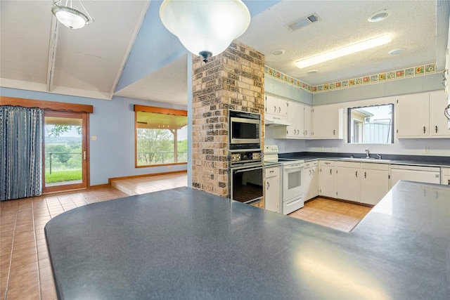 kitchen with dark countertops, visible vents, white cabinetry, white appliances, and under cabinet range hood