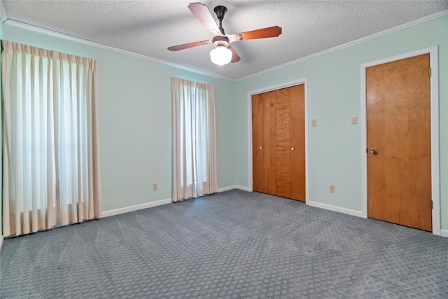 unfurnished bedroom with a textured ceiling, dark colored carpet, and crown molding