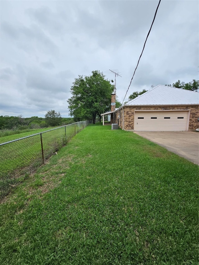 view of yard featuring fence and concrete driveway