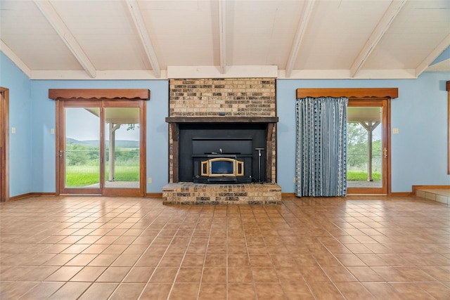 unfurnished living room with a mountain view, baseboards, and tile patterned floors