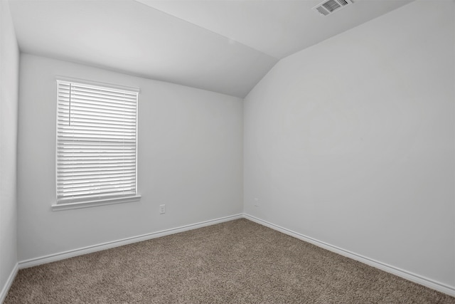 carpeted empty room with lofted ceiling