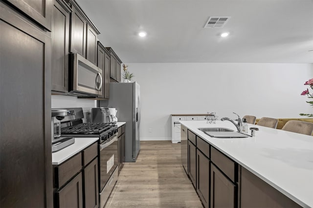 kitchen featuring light hardwood / wood-style flooring, stainless steel appliances, dark brown cabinetry, and sink