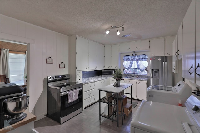 kitchen with white cabinets, a healthy amount of sunlight, a textured ceiling, and appliances with stainless steel finishes