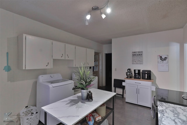 kitchen with light stone countertops, a textured ceiling, white cabinets, washer / clothes dryer, and a kitchen island