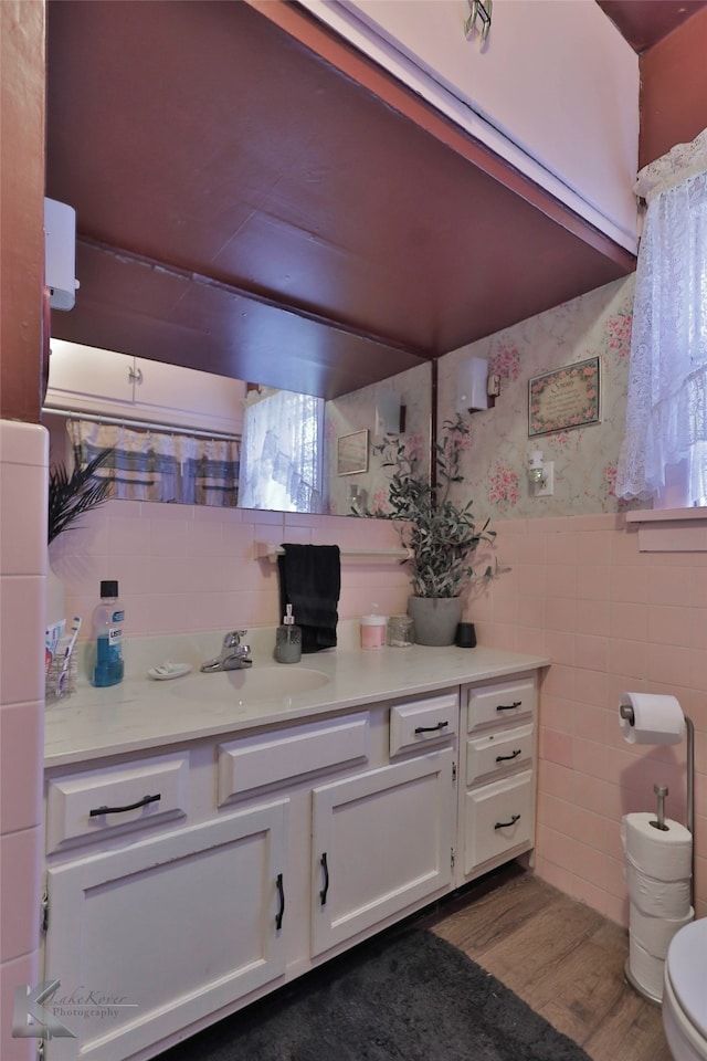 bathroom featuring hardwood / wood-style floors, vanity, toilet, and tile walls