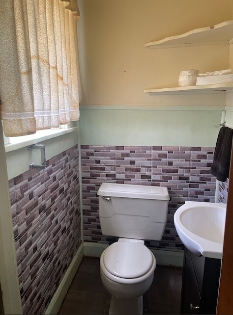 bathroom with vanity, tile walls, and toilet