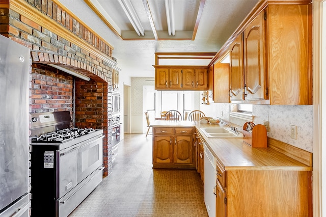 kitchen with white appliances, sink, brick wall, and light tile flooring