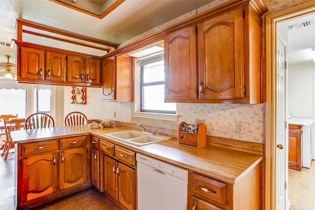 kitchen with sink, dishwasher, kitchen peninsula, and washer / clothes dryer