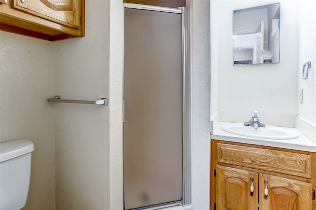 bathroom with an enclosed shower, toilet, and vanity with extensive cabinet space