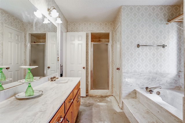 bathroom featuring a textured ceiling, large vanity, and separate shower and tub