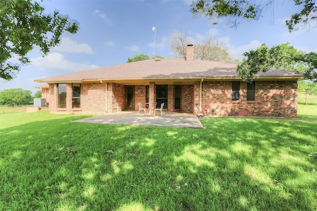 rear view of property with a yard and a patio