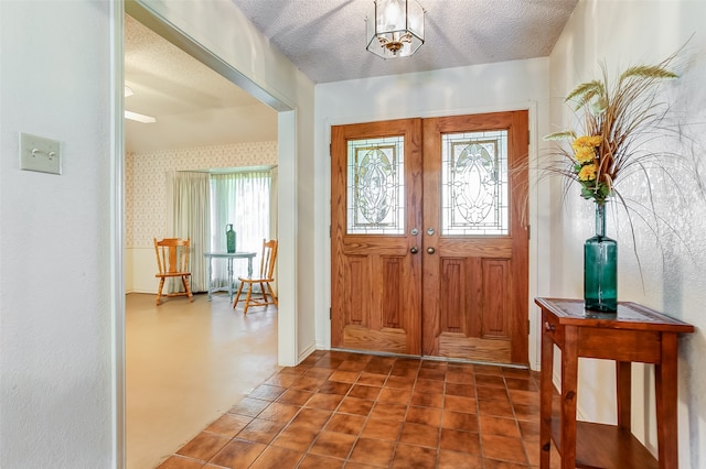 tiled entryway featuring french doors and a textured ceiling