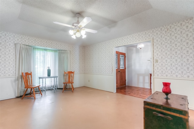 interior space with ceiling fan, tile flooring, vaulted ceiling, and a textured ceiling