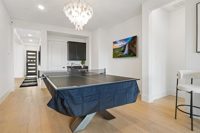 game room featuring light hardwood / wood-style flooring and a chandelier