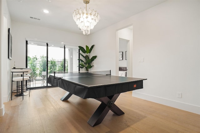 recreation room featuring an inviting chandelier and light hardwood / wood-style flooring