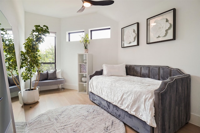 bedroom with ceiling fan, light wood-type flooring, and lofted ceiling