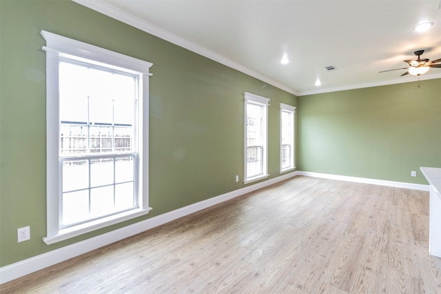 spare room featuring light hardwood / wood-style floors, crown molding, ceiling fan, and a wealth of natural light