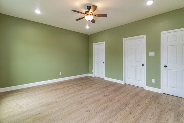 unfurnished bedroom featuring light hardwood / wood-style flooring, ceiling fan, and two closets