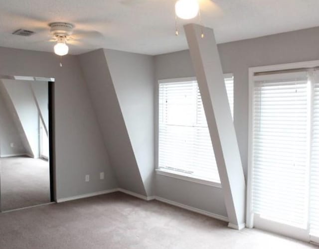 unfurnished room with ceiling fan and carpet floors