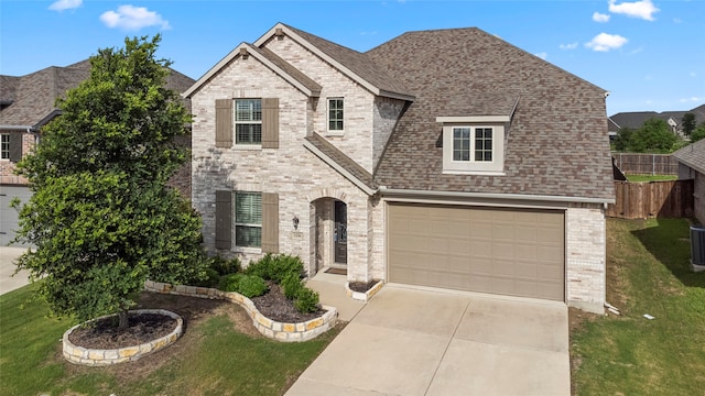 view of front of property featuring central AC, a garage, and a front yard