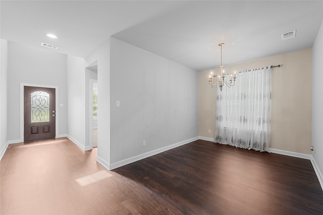 foyer entrance with wood-type flooring and a chandelier