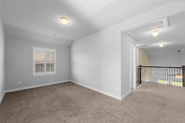 carpeted empty room with vaulted ceiling