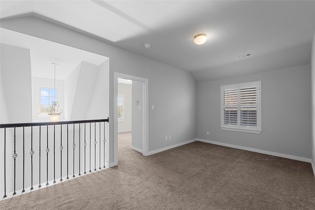 carpeted spare room with lofted ceiling