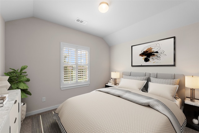 bedroom with vaulted ceiling and dark carpet