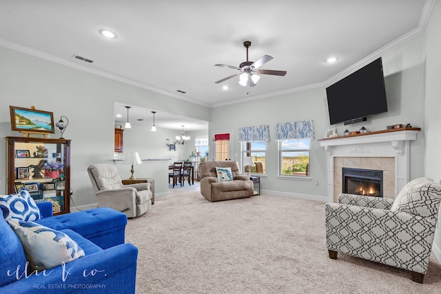 carpeted living room featuring ceiling fan with notable chandelier, a fireplace, and crown molding