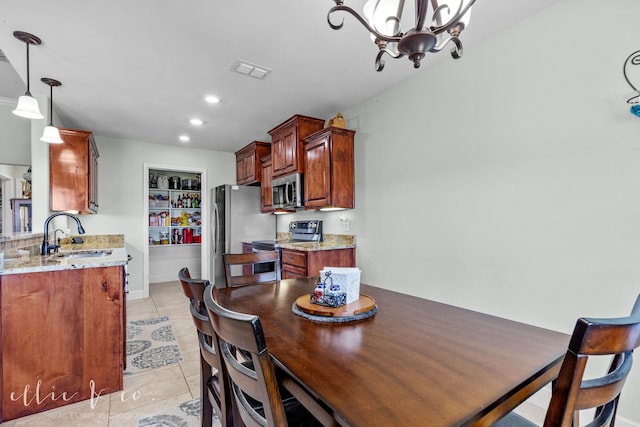 tiled dining area with an inviting chandelier and sink