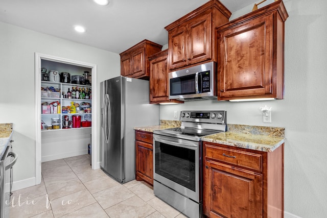 kitchen featuring stainless steel appliances, light tile floors, and light stone counters