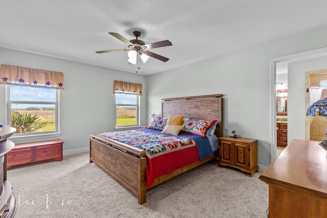 carpeted bedroom featuring ceiling fan, connected bathroom, fridge, and multiple windows