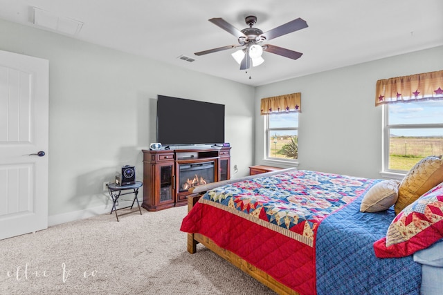 bedroom featuring multiple windows, ceiling fan, and carpet floors