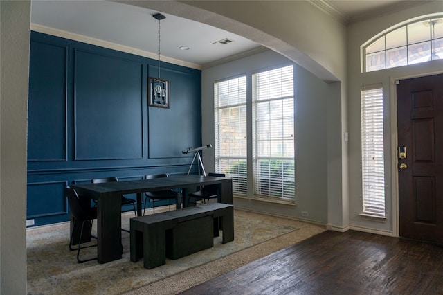 entryway featuring wood-type flooring, a wealth of natural light, and ornamental molding