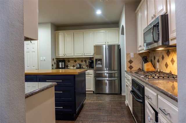 kitchen with appliances with stainless steel finishes, backsplash, and white cabinetry