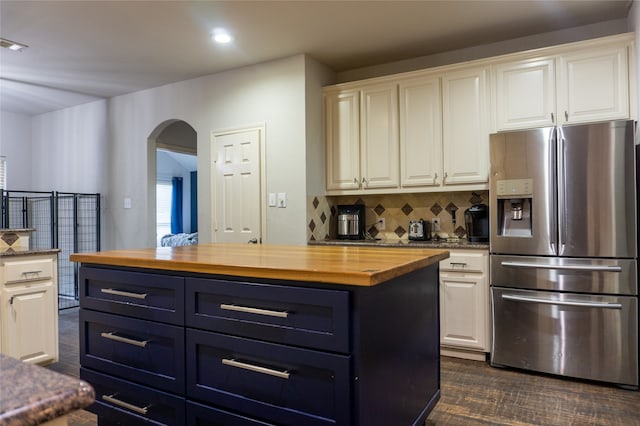 kitchen featuring a center island, butcher block countertops, white cabinets, and stainless steel refrigerator with ice dispenser