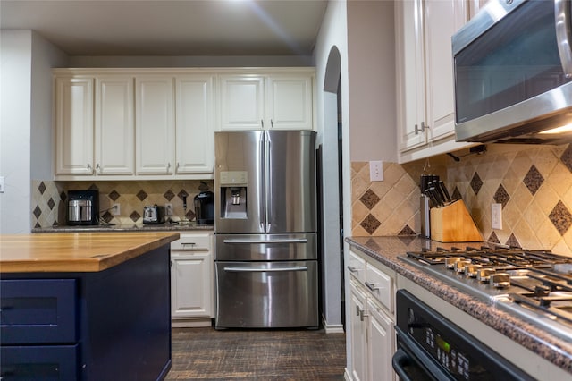 kitchen with tasteful backsplash, stainless steel appliances, and white cabinets