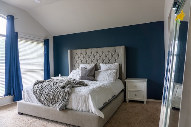 carpeted bedroom with lofted ceiling and multiple windows