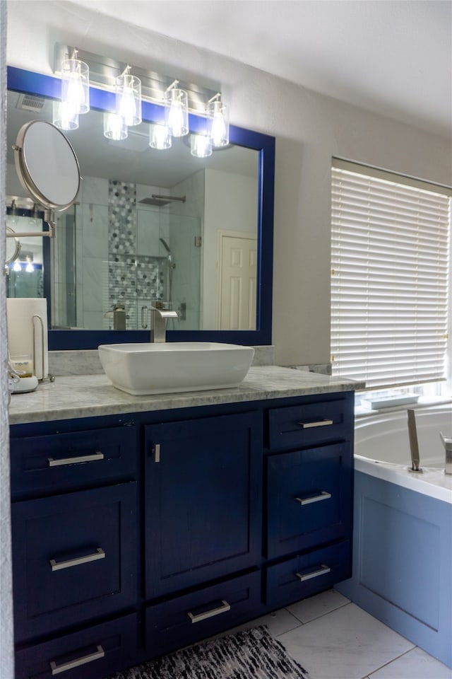 bathroom with tile flooring, vanity, and a bath