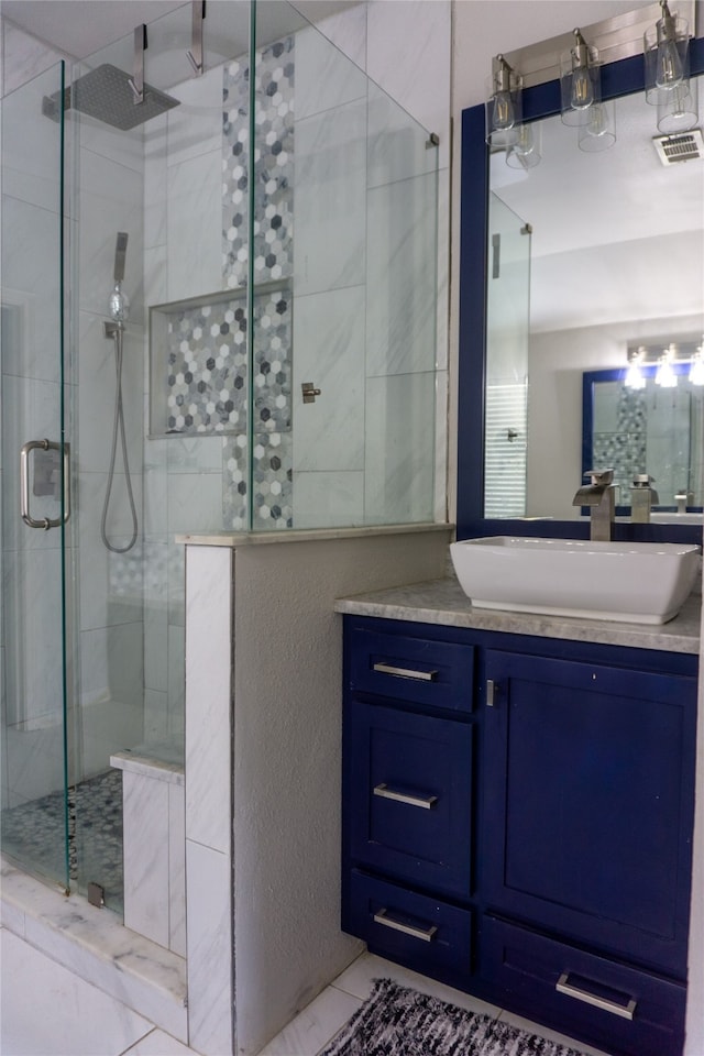 bathroom with a shower with door, vanity, and tile flooring