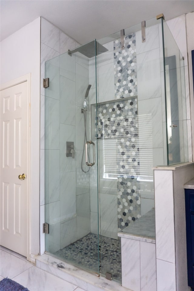 bathroom with a shower with door and tile flooring