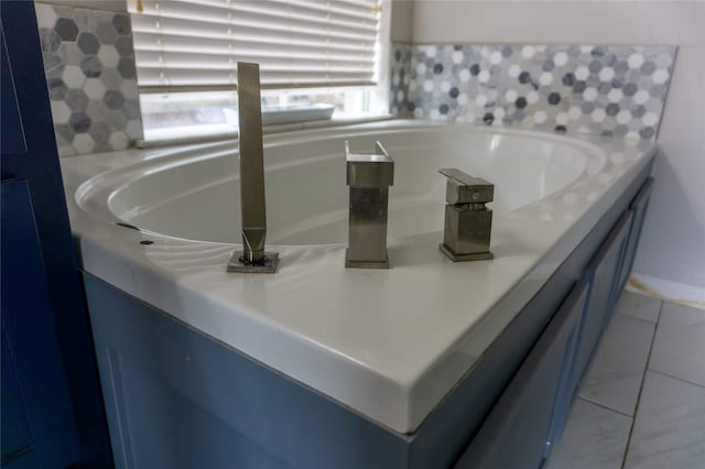 interior details featuring light tile flooring, vanity, and a bath