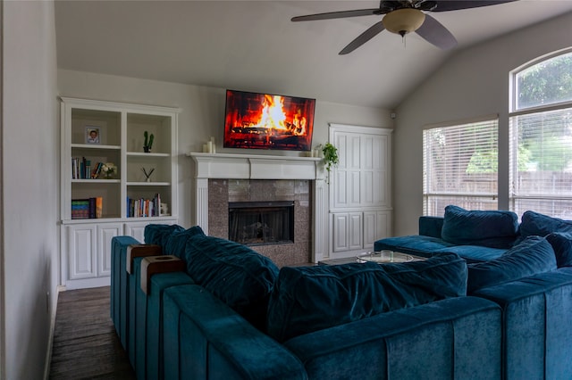 living room featuring lofted ceiling, ceiling fan, and a tiled fireplace