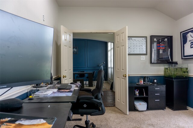 carpeted home office with lofted ceiling