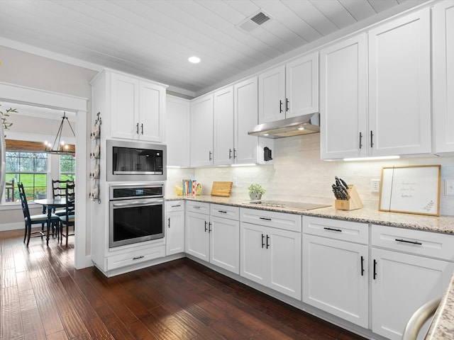 kitchen with white cabinets, oven, built in microwave, and tasteful backsplash