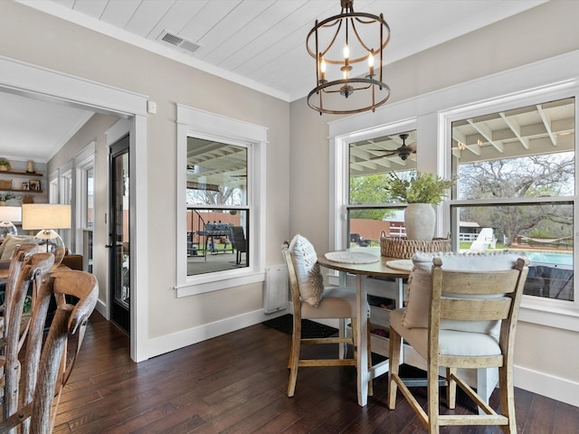 dining room with crown molding, a chandelier, and dark hardwood / wood-style flooring