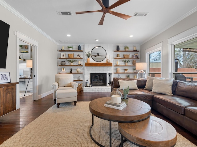 living room with a fireplace, ornamental molding, dark hardwood / wood-style floors, and ceiling fan